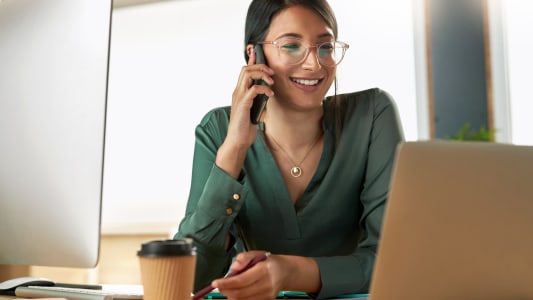 Appel t&eacute;l&eacute;phonique, ordinateur portable et femme d'affaires au bureau avec communication pour le rapport financier avec le client. T&eacute;l&eacute;phone portable, ordinateur et conseiller financier sur discussion mobile pour le projet d'investissement sur le lieu de travail.