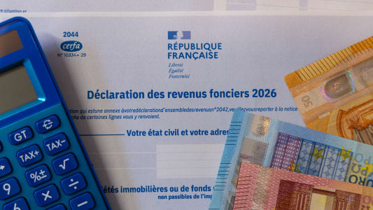 La d&eacute;claration annuelle de 2026 d'imp&ocirc;ts des revenus fonciers avec une calculette et des billets.