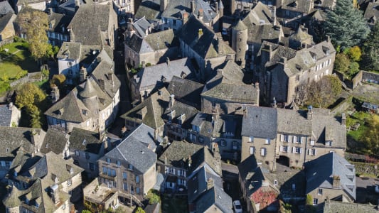 Vue a&eacute;rienne d?un village m&eacute;di&eacute;val aux toits gris en pierre. Salers, cantal