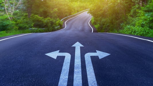 Fl&egrave;ches sur l'asphalte de la route avec trois choix de direction de fl&egrave;che, gauche, droite ou avancer sur la courbe de la route, concept de prise de d&eacute;cision difficile, motivation et croissance.