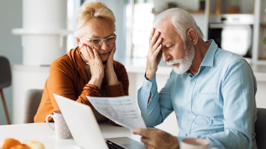 Des personnes &acirc;g&eacute;es inqui&egrave;tes en consultant des documents.