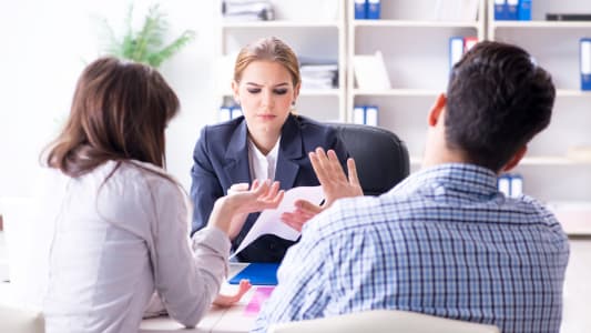 Une femme fait face &agrave; un homme et une femme, en pleine discussion