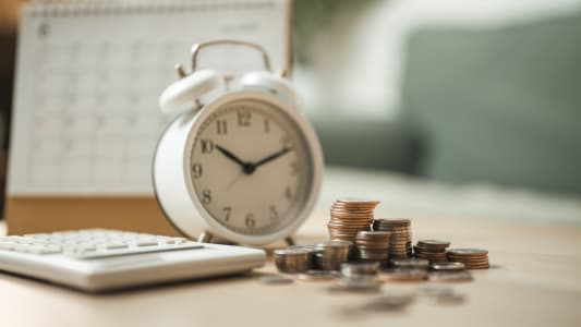 Un r&eacute;veil, des pi&egrave;ces de monnaie, une calculatrice et un calendrier.