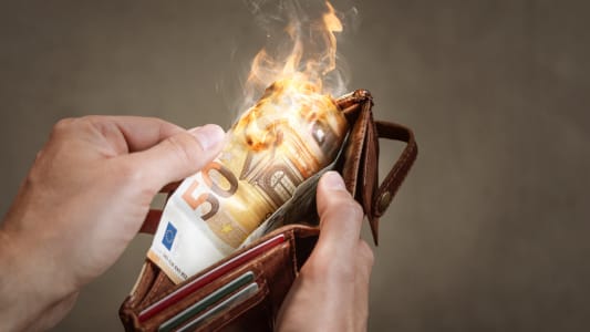 Un billet de 50 euros br&ucirc;lant dans un portefeuille