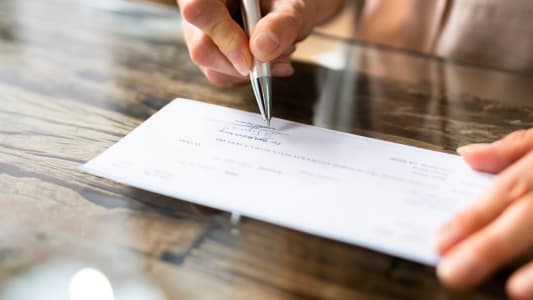 Main d'homme d'affaires signant un ch&egrave;que