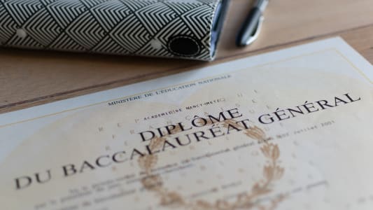 Diplôme du baccalauréat général posé sur une table en bois.
