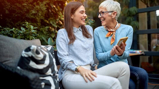 m&egrave;re montrant son t&eacute;l&eacute;phone portable &agrave; une fille, souriant et riant