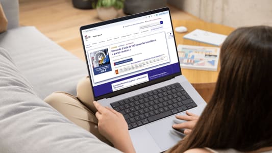 Femme sur canap&eacute; utilisant un ordinateur portable, site impots.gouv.fr.
