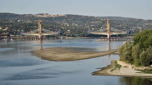 Vue a&eacute;rienne du faible niveau d'eau de la rivi&egrave;re sur le Danube &agrave; Novi Sad, en Serbie, avec la navigation de navires de marchandises suspendue et la construction d'un nouveau pont au loin.