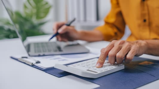 Jeune asiatique s&eacute;rieux, comptable faisant la comptabilit&eacute; entrepreneur propri&eacute;taire de petite entreprise dans le bureau avec le bilan, la d&eacute;claration de revenus et le budget de l'entreprise locale.