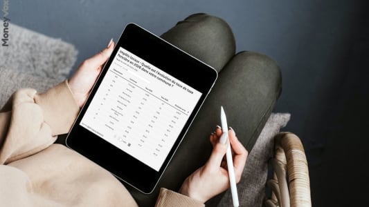 Personne tenant une tablette affichant un tableau de taux fonciers.