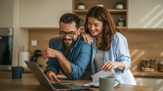 Couple planifiant les finances domestiques et gérant le budget dans la cuisine