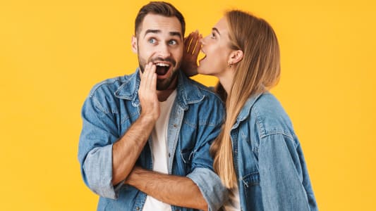 Image d'une femme heureuse chuchotant un secret &agrave; l'oreille d'un homme excit&eacute;