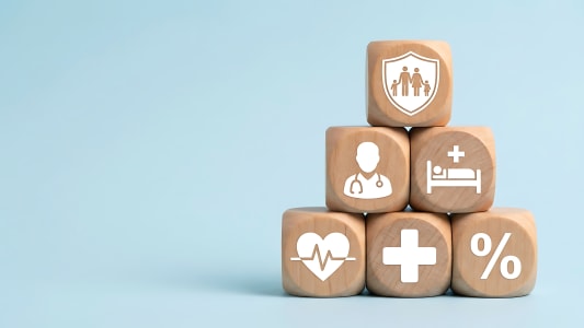 Pyramide de blocs en bois avec des symboles d'assurance santé.