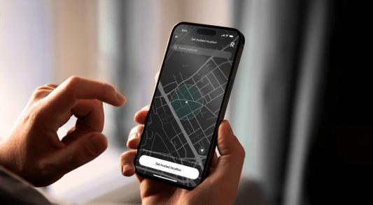 Main tenant un smartphone affichant une carte sur l'&eacute;cran.