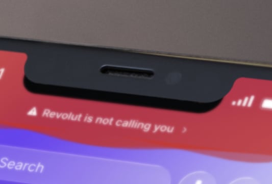 Gros plan sur un smartphone affichant une notification rouge.