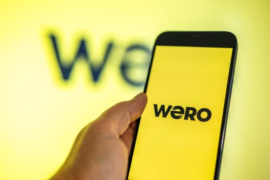 Main tenant un smartphone avec l'écran de paiement de l'application Wero