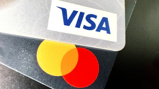 Deux cartes bancaires Visa et Mastercard superpos&eacute;es sur fond noir.