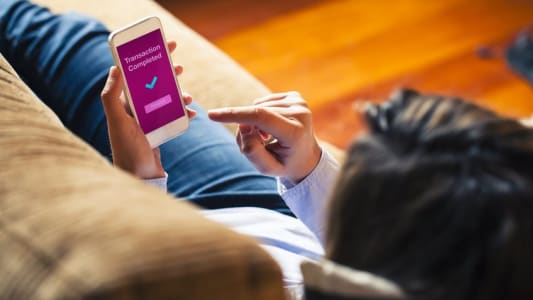 Femme payant en ligne depuis son mobile