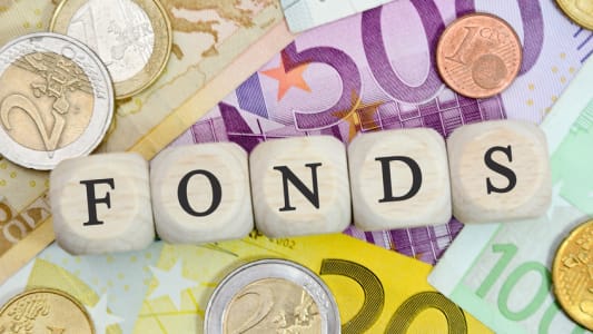 Ds crivant "fonds" sur un tapis de billets