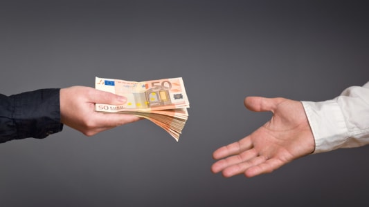 Une personne donnant des billets  une autre personne