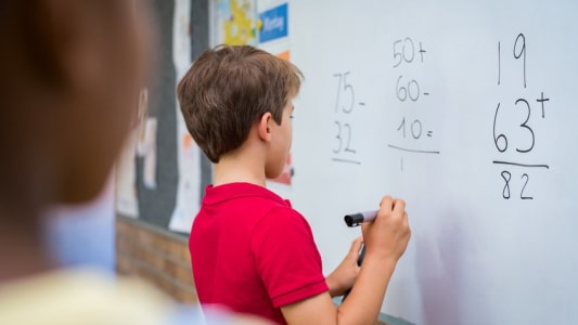 Elve faisant des calculs au tableau