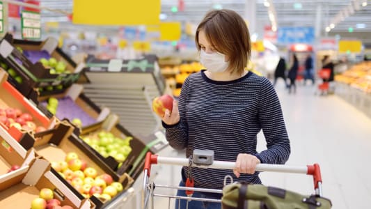 Femme avec masque faisant ses courses au supermarch
