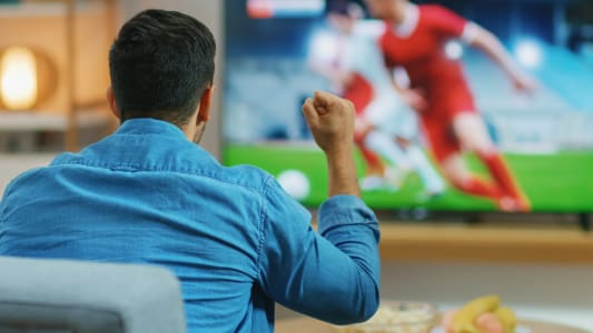 Un homme regarde du football  la tlvision