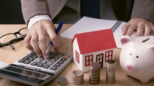 homme utilisant une calculatrice pour optimiser son prt immobilier