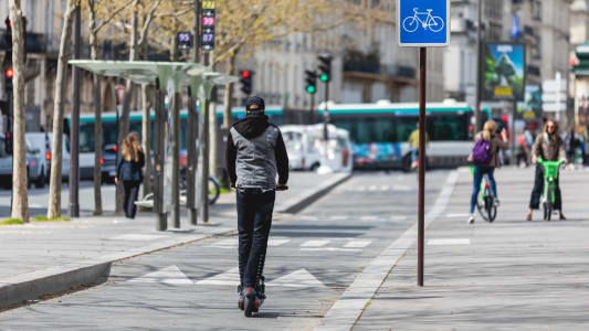Une trottinette lectrique roule en ville sur une piste cyclable