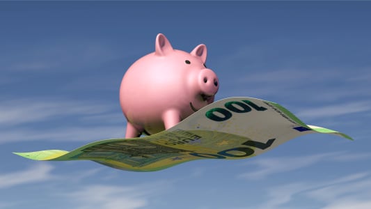Une tirelire qui vole sur un billet de 100 euros.
