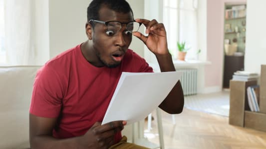 Un homme regarde un document l'air trs tonn.