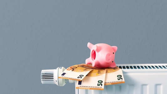 Des billets et une tirelire sur un radiateur.