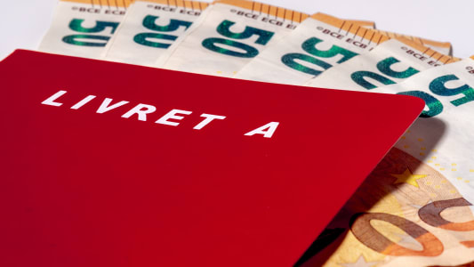 Une chemise avec inscrit livret A et des billets de 50 euros.