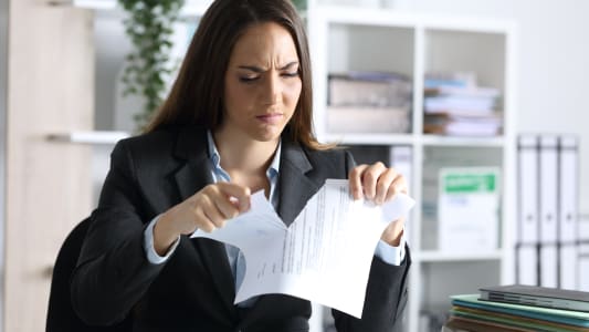 Une femme dchire un document.